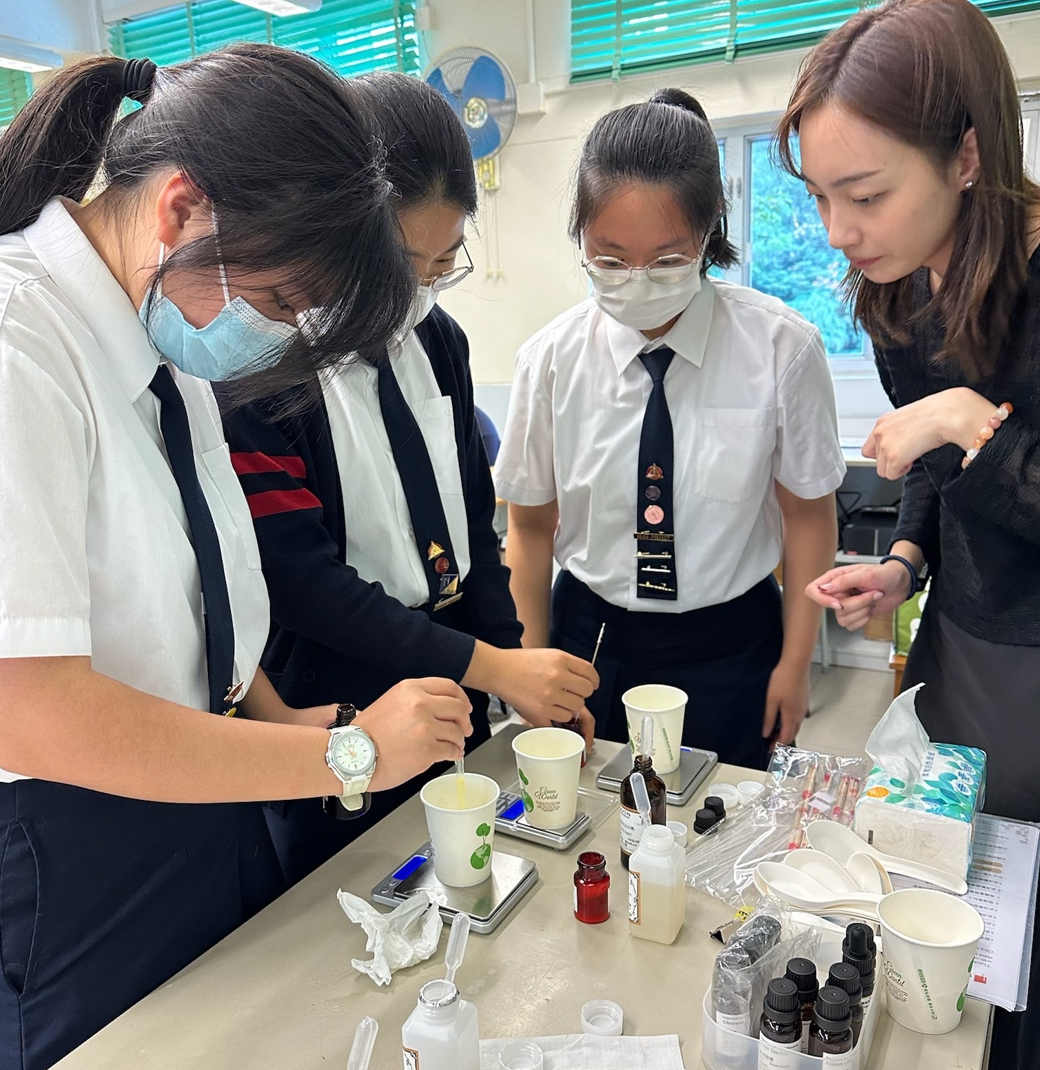 A group of children painting on a tableDescription automatically generated