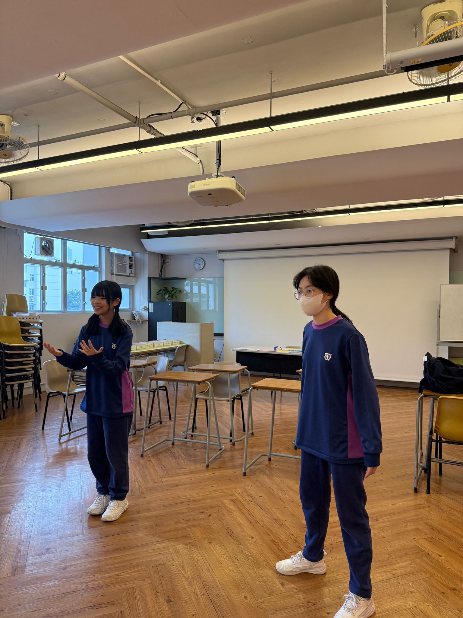A person standing in front of a classroomDescription automatically generated