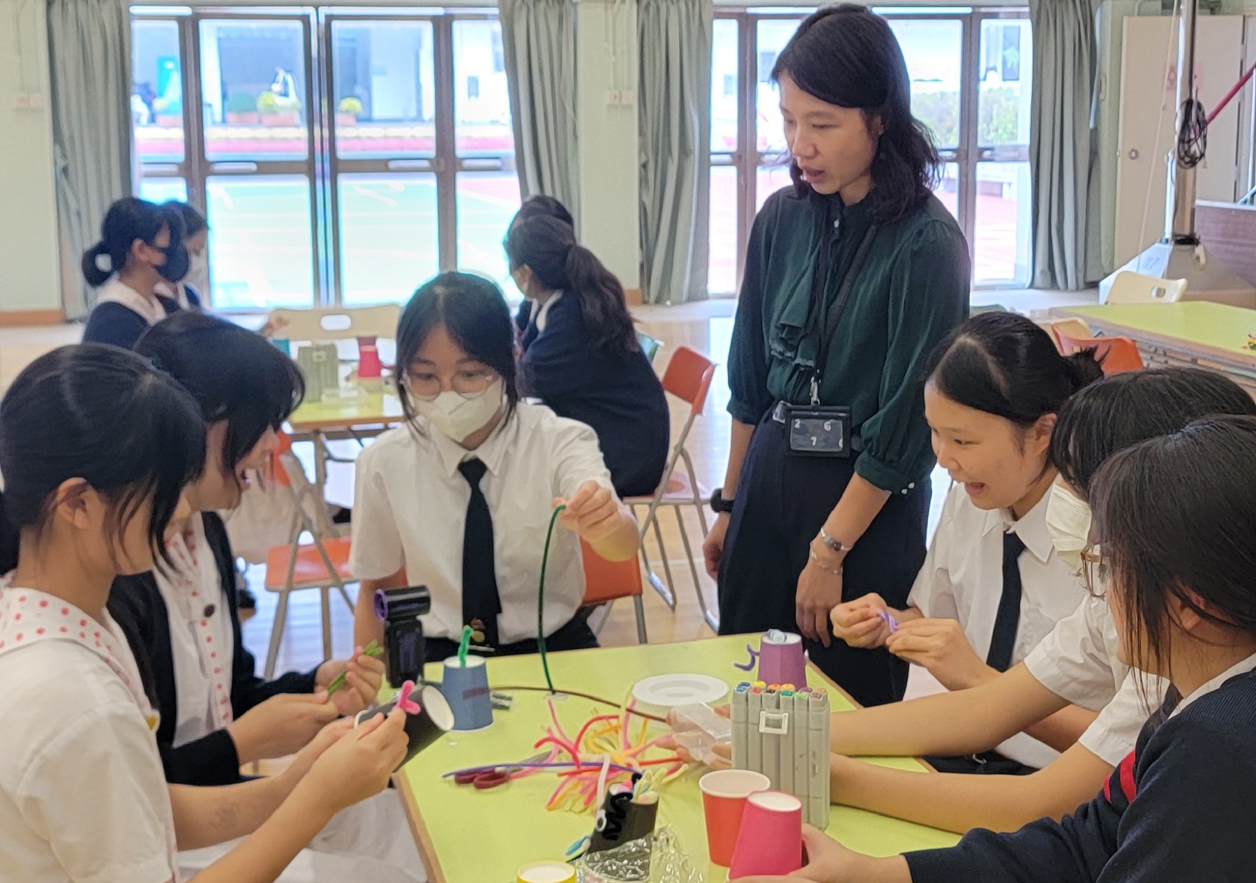 A group of children painting on a tableDescription automatically generated