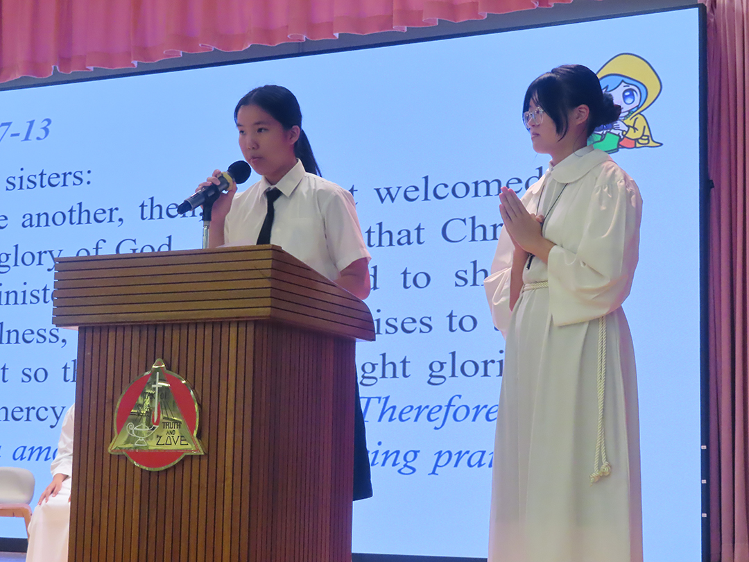 A person standing in front of a bannerDescription automatically generated