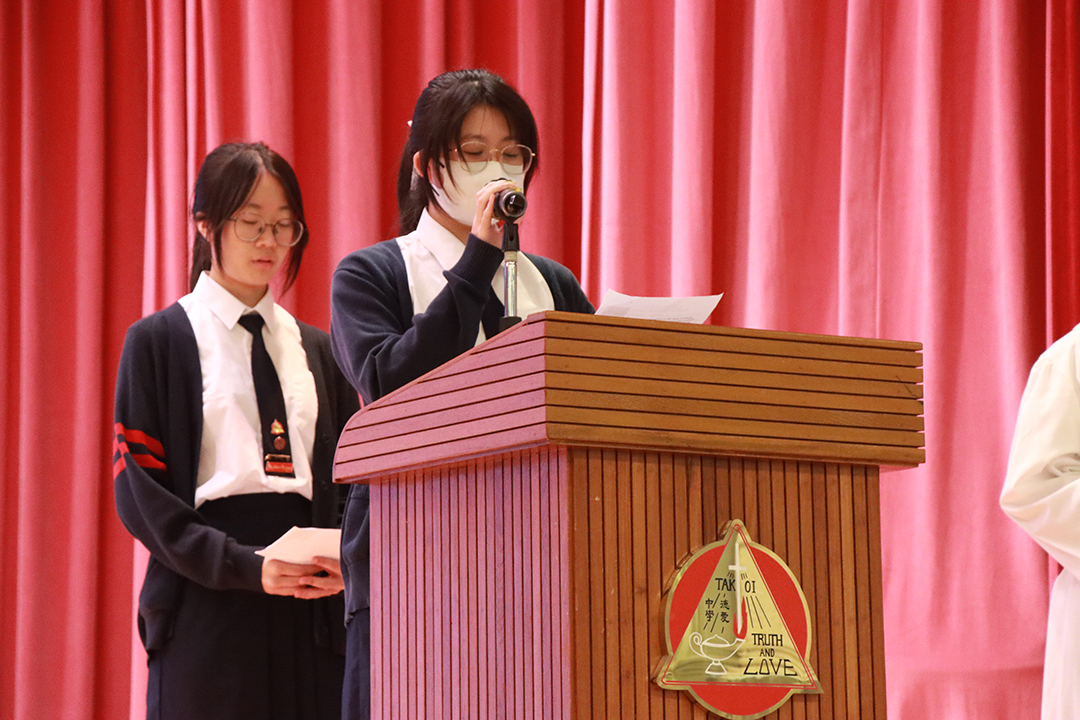 A person standing in front of a bannerDescription automatically generated