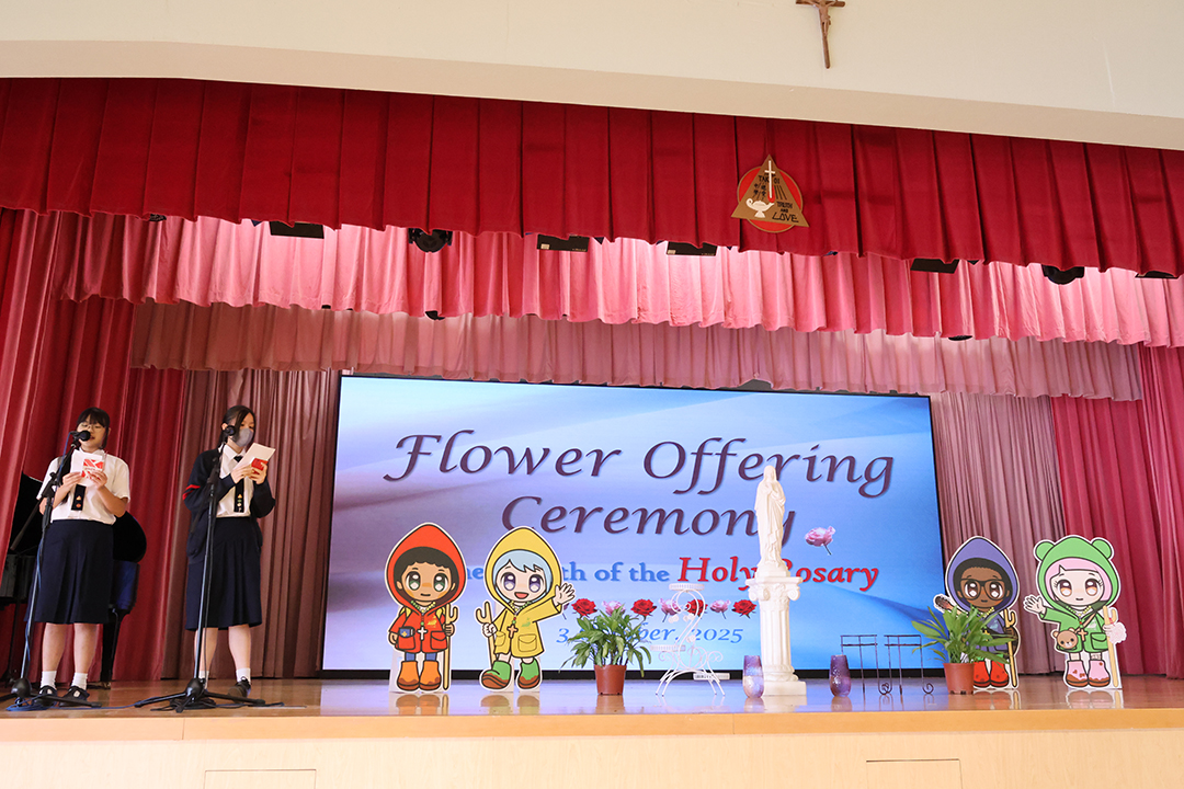 A person standing in front of a bannerDescription automatically generated