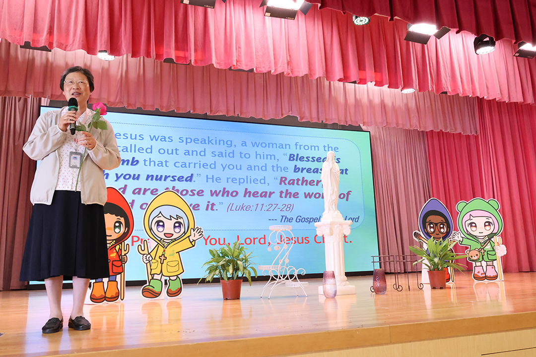 A person standing in front of a bannerDescription automatically generated