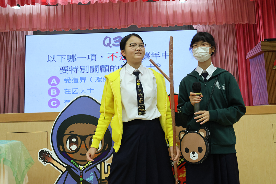A person standing in front of a bannerDescription automatically generated