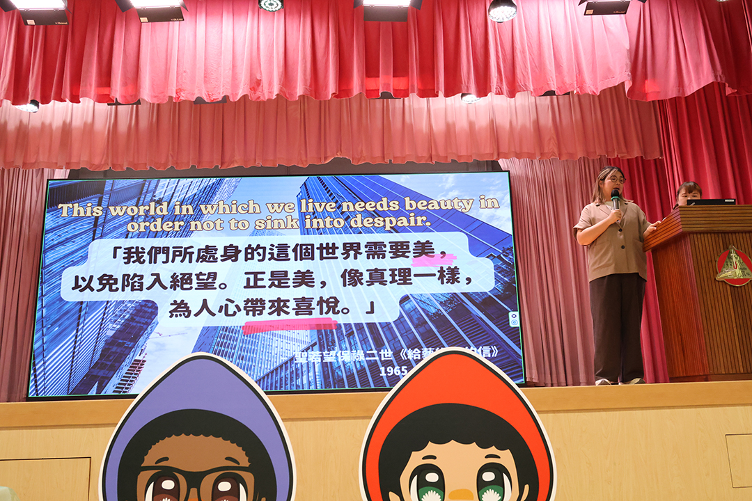 A person standing in front of a bannerDescription automatically generated